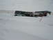 1979 Ford F-150 - Several vehicles are stuck in deep snowdrifts on a bleak winter day.