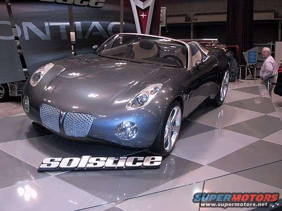 Gray Pontiac Solstice concept car on display floor with 'SOLSTICE' badge