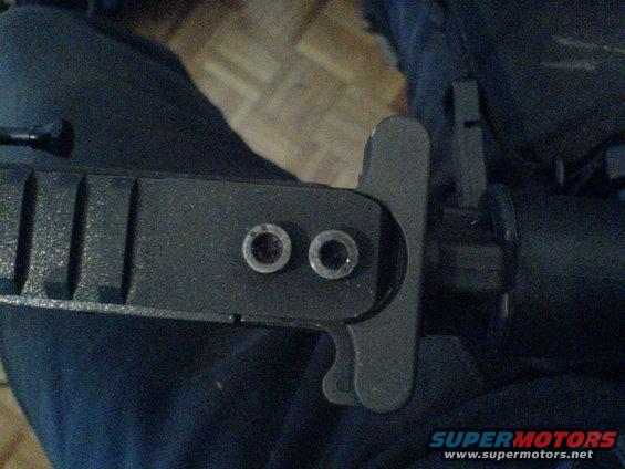 Close-up of firearm part with two visible rivets