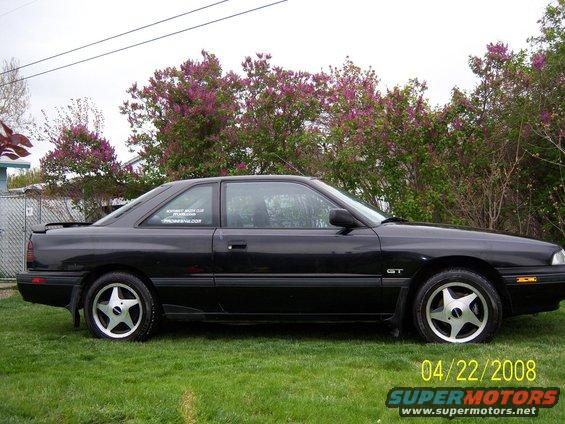 1989 Mazda MX-6 GT coupe parked on grass, side view. Sticker on rear window reads 'NORTHWEST MAZDA CLUB'