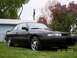 1989 Mazda MX-6 - A black 1989 Mazda MX-6 GT coupe is shown from the front 3/4 angle on a grassy lawn.