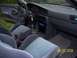 1989 Mazda MX-6 - The interior of a car is shown, striped cloth seats, a dashboard with gauges, and a center console with an aftermarket stereo.