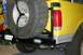 1984 Ford Bronco - Rear view of a yellow Ford Bronco showing its spare tire carrier and aftermarket bumper.