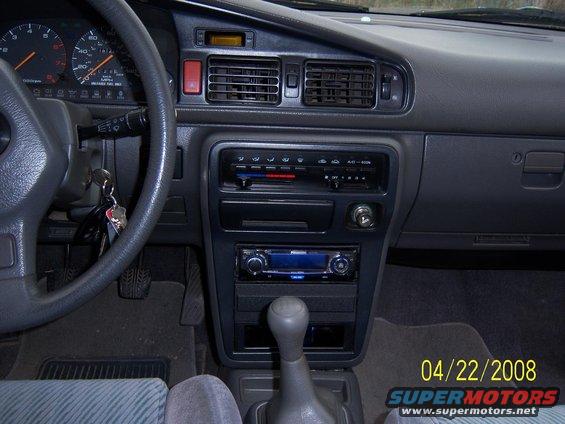1989 Mazda MX-6 interior showing dashboard, steering wheel, gear shift, and aftermarket stereo