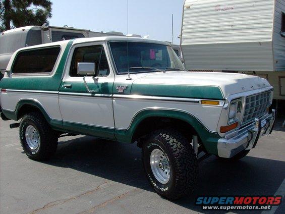 White and green Ford Bronco parked next to a trailer