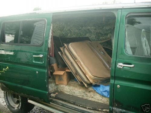 Green van interior loaded with stacked doors and a cardboard box