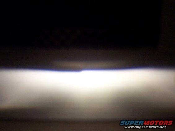 Headlight beam with SUPERMOTORS.NET watermark