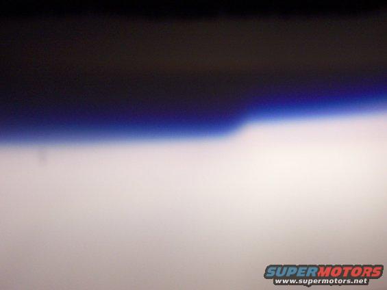 Horizon line with dark sky above and bright sky below, SUPERMOTORS.NET logo at bottom right