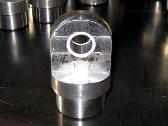 Machined metal part with circular opening and visible machining marks