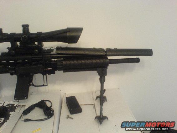 Sniper rifle with scope, suppressor, and bipod on a table