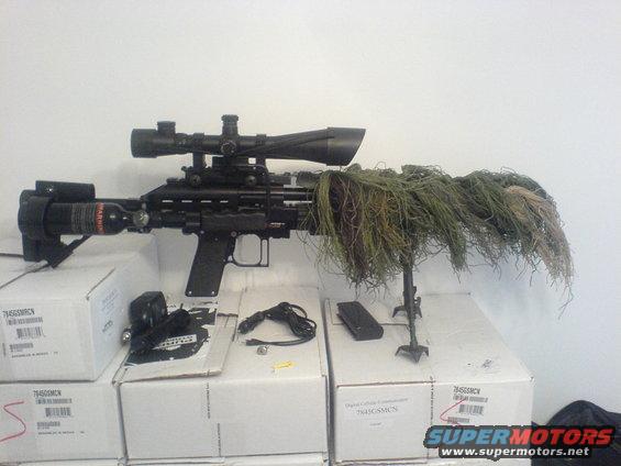 Sniper rifle with scope, camouflage netting, and CO2 tank