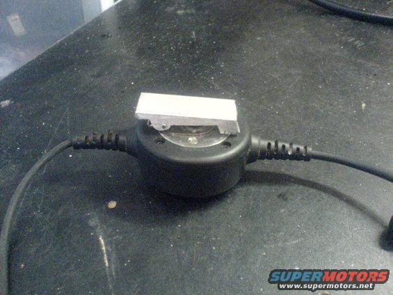 Metal part on black circular device with cables