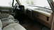 1990 Ford Bronco - The interior of a truck features a tan dashboard, steering wheel, and cloth seats with a center console.