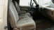 1990 Ford Bronco - The interior of a 1992 Ford Bronco shows tan fabric seats and a dashboard with a center console.