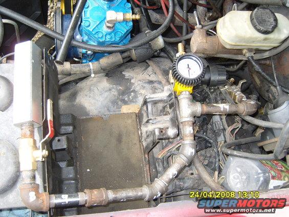 Engine bay with blue compressor and pressure gauge
