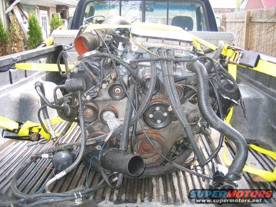 Engine secured with yellow straps in the bed of a pickup truck
