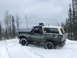 1988 Ford Bronco - A 1988 Ford Bronco navigates a snowy trail, its off-road tires kicking up snow.