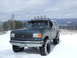 1988 Ford Bronco - This SUV, likely a 1987 model, is equipped for off-road conditions with large tires and auxiliary lights on the roof rack.