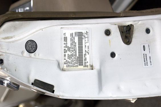 White door jamb with manufacturer sticker showing VIN and build date