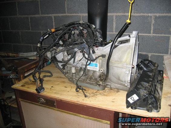 Transmission assembly with wiring harness and a black engine cover with a '12' sticker