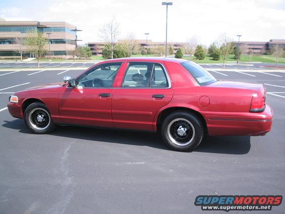 Red 2001 Ford Crown Victoria sedan parked in a lot, side view