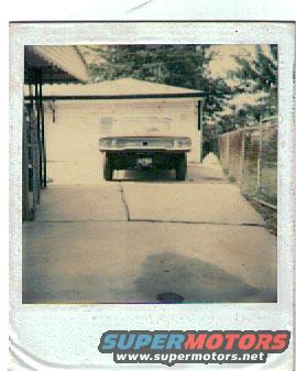 Rear view of a light-colored pickup truck parked in a driveway
