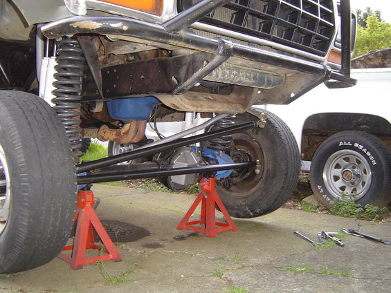 1978 Ford Bronco front suspension on jack stands, showing modified components and a blue differential