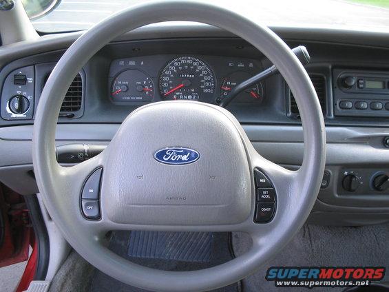 2001 Ford Crown Victoria interior showing steering wheel with Ford logo, dashboard gauges, and center console