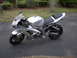 2002 Buell Lightning w/Fairing - A silver Kawasaki Ninja motorcycle is parked on a paved surface with a grassy area and trees in the background.