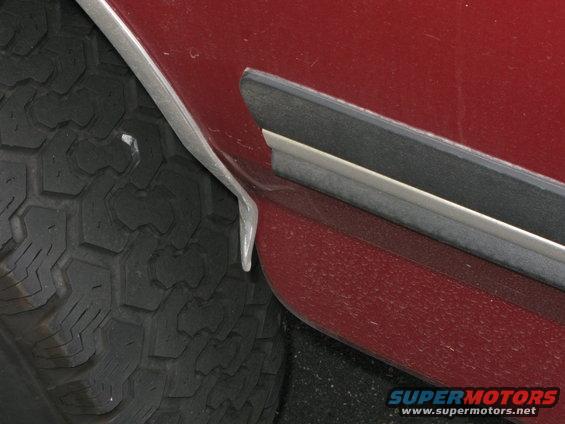 Red vehicle fender trim detail next to tire tread