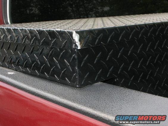Black diamond plate toolbox on red truck bed