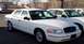 1999 Ford Crown Victoria - A white sedan parked outdoors, with another similar vehicle visible to its right.