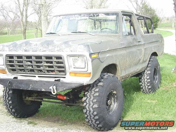Lifted 1978 Ford Bronco with big tires and a roll cage, parked outside