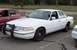 1996 Ford Crown Victoria - A white 1996 Ford Crown Victoria police car is parked next to another vehicle.