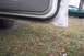 1996 Ford Crown Victoria - The lower part of an open car door reveals rust on the sill, with a green car in the background.