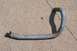1996 Ford Crown Victoria - A metal oil cooler hose with a black fitting and clamp is shown on a concrete surface.
