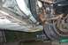 1996 Ford Crown Victoria - The underside of a vehicle displays extensive rust and damage, with a visible tire and suspension parts.