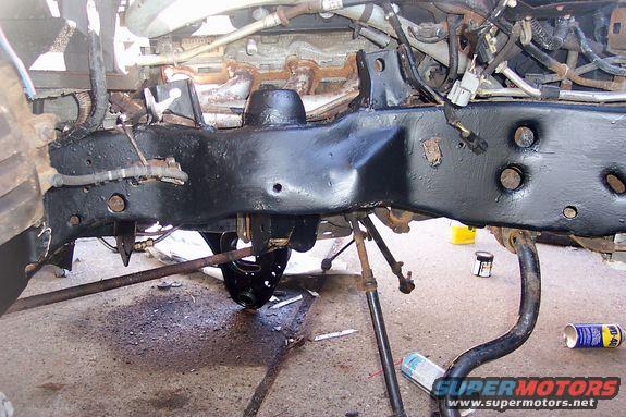 Black painted vehicle frame and suspension parts with WD-40 can