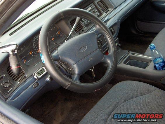 1996 Ford Crown Victoria interior showing dashboard, steering wheel, and center console with a water bottle