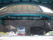 1993 Mazda MX-6 - Trunk interior of a 1993 Mazda MX-6, showing a strut bar and various items stored within.