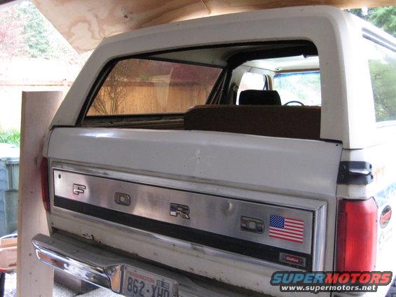 White 1980 Ford Bronco rear with 'FORD' lettering and American flag decal