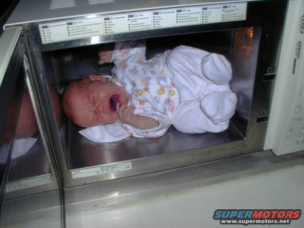 Crying baby in a microwave oven, with control panel visible above