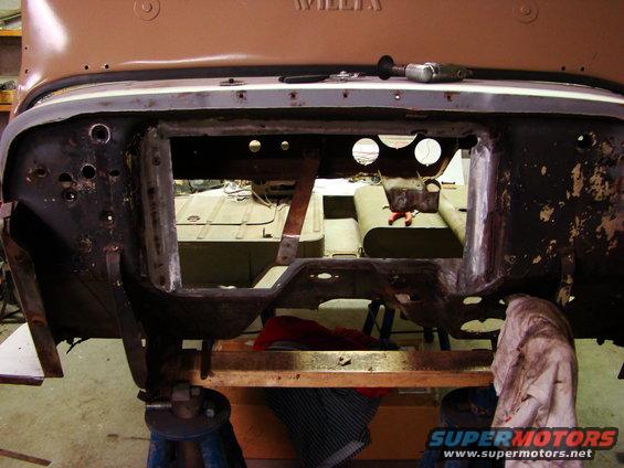 close-up of a vehicle's disassembled frame, with another vehicle visible in the background