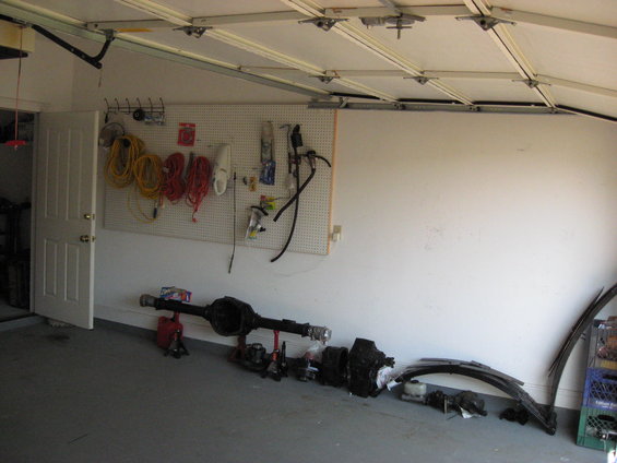Interior of a garage with a dark-colored vehicle partially visible on the right