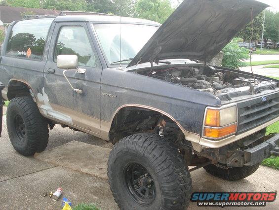 Dark blue 1989 Ford Bronco II with hood open, lifted suspension, and large tires
