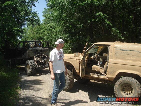 Tan 1989 Ford Bronco II with doors open, parked next to a black off-road vehicle