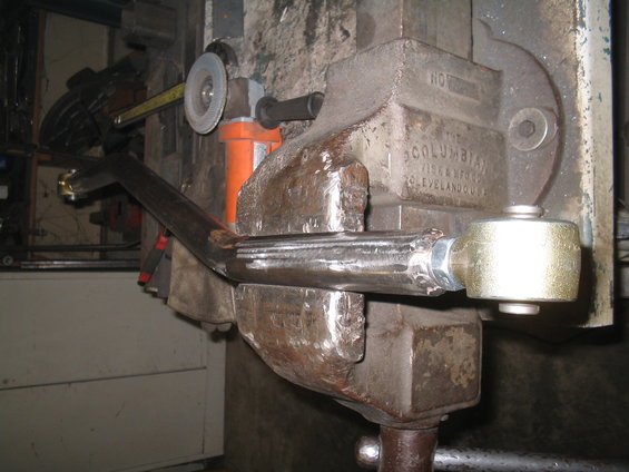 Metal rod clamped in a vise with an angle grinder nearby