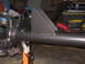 1979 Ford Bronco - Custom bracket welded onto a vehicle axle assembly, shown on a jack stand in a workshop.