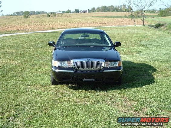 Black sedan with chrome grille parked on grass