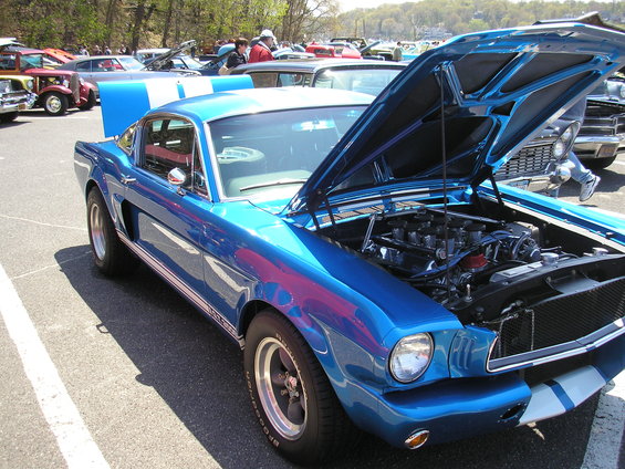 Blue 1967 Ford Mustang Shelby GT500, hood open, showing engine. White racing stripes on hood and sides
